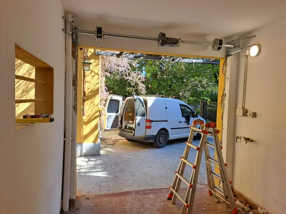Lavoro di Eugenio: montaggio dell'albero con molle e motore sopra l'apertura del garage