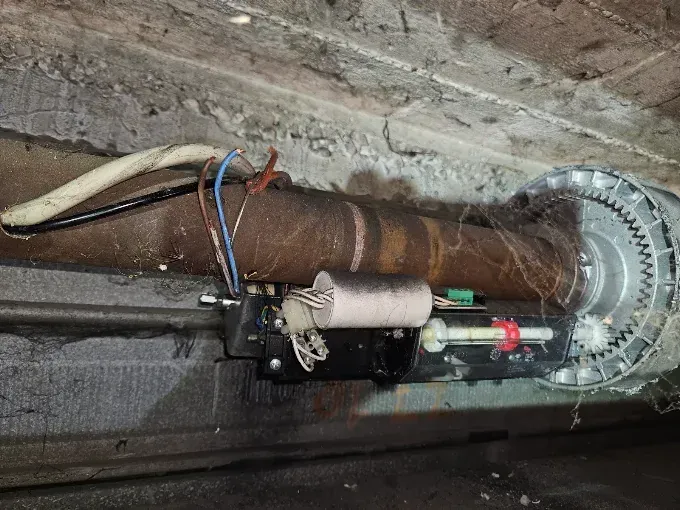 Riparazione serrande a Barca: vecchio motore di serranda con corona dentata montato sull'albero
